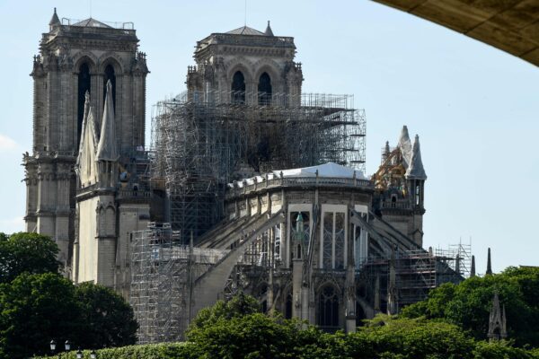 (FILES) This file photo taken on May 31, 2019 shows scaffoldings set up on Notre-Dame de Paris cathedral, under repair after it was badly damaged by a huge fire on April 15, in the French capital Paris. – At the end of 2019, the Notre-Dame consolidation project is focused on the preparations for the dismantling of the huge scaffolding installed before the fire, which poses a potential danger for the cathedral. A 94-meter high crane, will be installed in December on the south side along the Seine, to take down to the ground one by one the pieces of this scaffolding. (Photo by Bertrand GUAY / AFP)