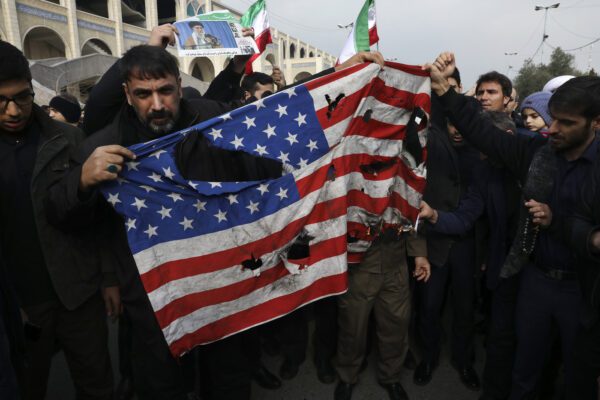 Protesters burn a U.S. flag during a demonstration over the U.S. airstrike in Iraq that killed Iranian Revolutionary Guard Gen. Qassem Soleimani, in Tehran, Iran, Jan. 3, 2020. Iran has vowed "harsh retaliation" for the U.S. airstrike near Baghdad’s airport that killed Tehran’s top general and the architect of its interventions across the Middle East, as tensions soared in the wake of the targeted killing. (AP Photo/Vahid Salemi)