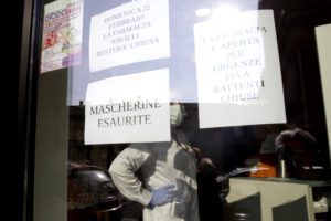 A note reading in Italian " Masks sold out " hangs on the window of a pharmacy in Codogno, near Lodi, Northern Italy, Saturday, Feb. 22, 2020. A dozen towns in northern Italy are on effective lockdown after the new virus linked to China claimed a first fatality in Italy and sickened an increasing number of people. The secondary contagions have prompted local authorities in towns of Lombardy and Veneto to order schools, businesses, and restaurants closed, and to cancel sporting events and Masses. (AP Photo/Luca Bruno)