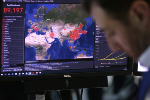 A worker at the Emergency Response Coordination Center in Brussels views a screen with graphics regarding COVID-19, Monday, March 2, 2020. European Commission President Ursula von der Leyen on Monday said the coronavirus risk level has risen from moderate to high for people living in the 27-country bloc. (AP Photo/Virginia Mayo)