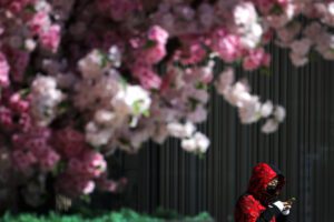A masked woman browses her smartphone as she walks by the Wangfujing shopping district in Beijing, Tuesday, March 10, 2020. For most people, the new coronavirus causes only mild or moderate symptoms, such as fever and cough. For some, especially older adults and people with existing health problems, it can cause more severe illness, including pneumonia. (AP Photo/Andy Wong)