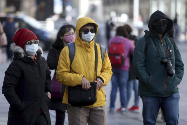 People wear protective masks downtown in Vienna, Austria, Sunday, March 15, 2020. The austrian government restricts freedom of movement. Bars and restaurants are also no longer allowed to open from Tuesday. Only for most people, the new coronavirus causes only mild or moderate symptoms, such as fever and cough. For some, especially older adults and people with existing health problems, it can cause more severe illness, including pneumonia. (AP Photo/Ronald Zak)