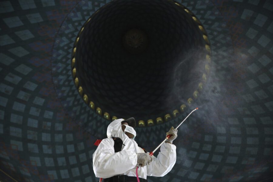 A worker sprays disinfectant at Al Akbar mosque amid fears of coronavirus outbreak in Surabaya, East Java, Indonesia, Tuesday, March 17, 2020. For most people, the new coronavirus causes only mild or moderate symptoms. For some, especially older adults it can cause more severe illness. (AP Photo/Trisnadi)
