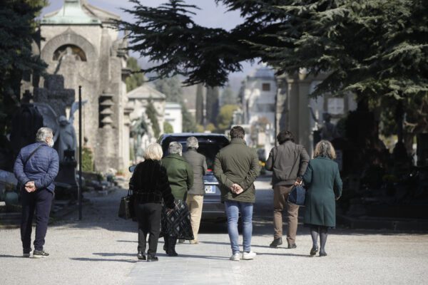 Relatives walk behind a hearse carrying a coffin inside the Monumentale cemetery, in Bergamo, Italy, Tuesday, March 17, 2020. Bergamo is one of the cities most hit by the new coronavirus outbreak in northern Italy. For most people, the new coronavirus causes only mild or moderate symptoms. For some it can cause more severe illness, especially in older adults and people with existing health problems. (AP Photo/Luca Bruno)