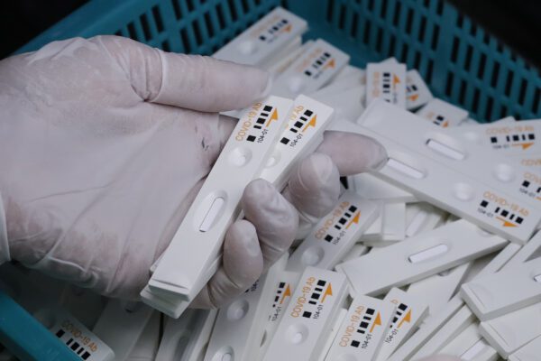 An employee holds antibody test cartridges of the ichroma COVID-19 Ab testing kit used in diagnosing the coronavirus on a production line of the Boditech Med Inc. in Chuncheon, South Korea, Friday, April 17, 2020. Boditech Med recently started exporting its antibody-based virus test kits to various countries. (AP Photo/Lee Jin-man)