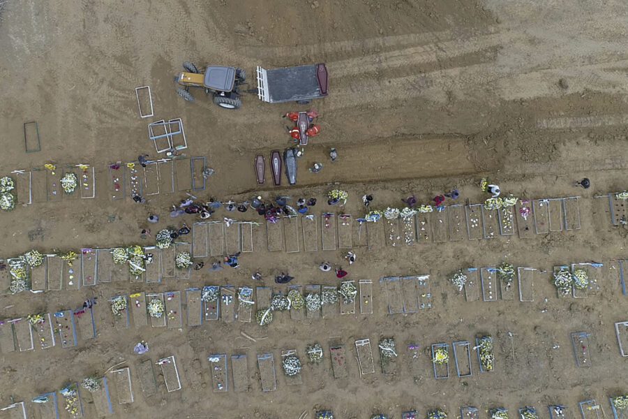 Workers carry a coffin into a common pit at the Nossa Senhora Aparecida cemetery, amid the new coronavirus pandemic in Manaus, Amazonas state, Brazil, Wednesday, April 22, 2020. (AP Photo/Emerson Cardoso)