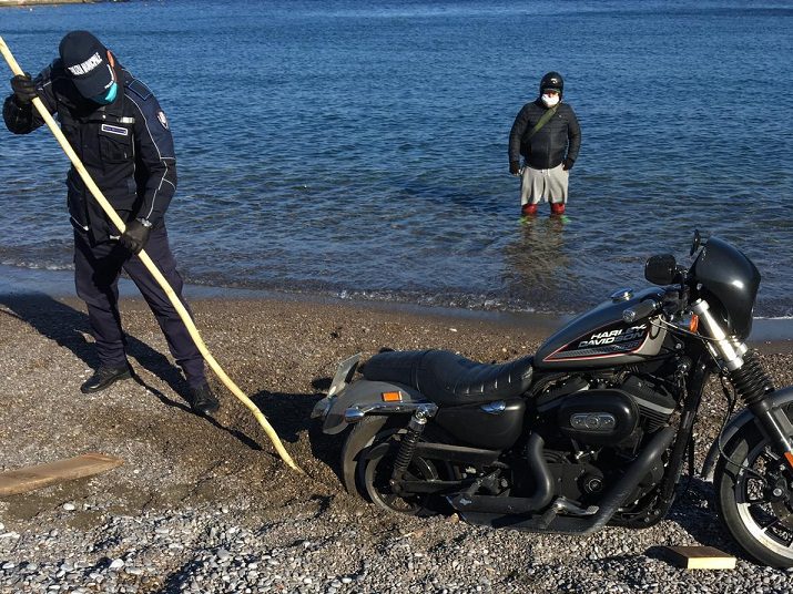 Va in spiaggia con la moto e si arena, i vigili la recuperano mentre lui osserva tutto dal mare