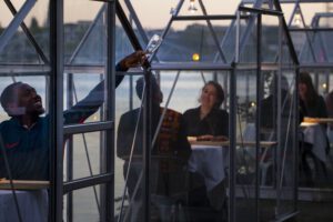 A volunteers asks for a refill as staff at the Mediamatic restaurant serves food to volunteers seated in small glasshouses during a try-out of a setup which respects social distancing abiding by government directives to combat the spread of the COVID-19 coronavirus in Amsterdam, Netherlands, Tuesday, May 5, 2020. (AP Photo/Peter Dejong)