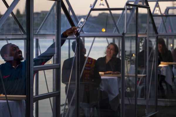 A volunteers asks for a refill as staff at the Mediamatic restaurant serves food to volunteers seated in small glasshouses during a try-out of a setup which respects social distancing abiding by government directives to combat the spread of the COVID-19 coronavirus in Amsterdam, Netherlands, Tuesday, May 5, 2020. (AP Photo/Peter Dejong)