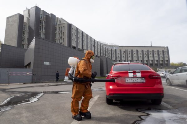 A Russian Emergency Situation worker disinfects a fire department car near the scene of a fire at St. George Hospital in St. Petersburg, Russia, Tuesday, May 12, 2020. A fire at St. George Hospital has killed five coronavirus patients. Russian emergency officials said all five had been put on ventilators. The emergency officials told the state Tass new agency the fire broke out in an intensive care unit and was put out within half an hour. (AP Photo/Dmitry Lovetsky)