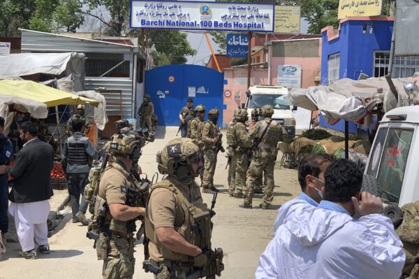Afghan and foreign security personnel stand guard in front of a hospital after gunmen attacked, in Kabul, Afghanistan, Tuesday, May 12, 2020. Gunmen stormed a maternity hospital in the western part of the Afghan capital, setting off a gun battle with the police and several people were reported wounded. (AP Photo/Rahmat Gul)