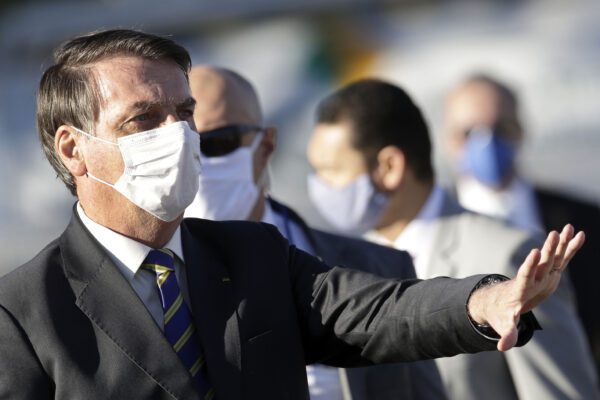 Brazil’s President Jair Bolsonaro gestures to supporters before the start of a flag raising ceremony outside Alvorada palace, the presidential residence in Brasilia, Brazil, Tuesday, May 12, 2020. The morning ceremony flew Brazil’s flag at half mast to mourn those who have died from the new coronavirus. (AP Photo/Eraldo Peres)