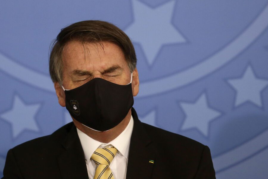 Brazil’s President Jair Bolsonaro, wearing a mask amid the COVID-19 pandemic, briefly shuts his eyes during an event promoting a government campaign against domestic violence at Planalto presidential palace in Brasilia, Brazil, Friday, May 15, 2020. (AP Photo/Eraldo Peres)