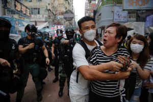 A woman argues with police as she was told to stay away from the area in Mongkok, Hong Kong, Wednesday, May 27, 2020. Thousands of protesters shouted pro-democracy slogans and insults at police in Hong Kong before lawmakers later Wednesday debate a bill criminalizing abuse of the Chinese national anthem in the semi-autonomous city. (AP Photo/Kin Cheung)