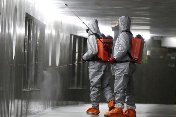 Workers wearing protective suits spray disinfectant at the Centrum subway station in Warsaw, Poland, Monday, April 6, 2020. The COVID-19 coronavirus causes mild or moderate symptoms for most people, but for some, especially older adults and people with existing health problems, it can cause more severe illness or death. (AP Photo/Czarek Sokolowski)