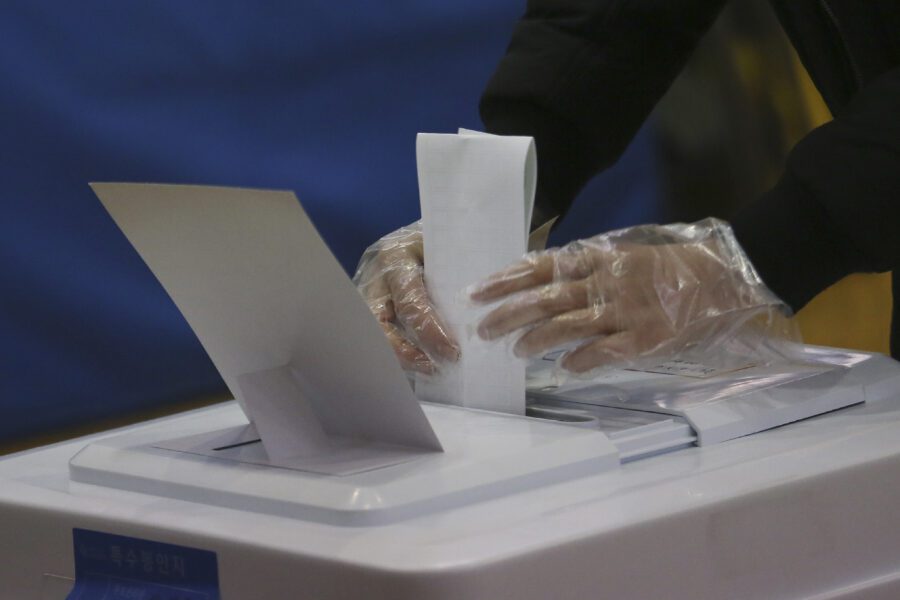 A voter wearing plastic gloves to help protect against the spread of the new coronavirus casts early vote for the upcoming parliamentary election at a polling station in Seoul, South Korea, Friday, April 10, 2020. The elections will be held on April 15 at about 14,300 polling stations all over the nation to pick lawmakers. The new coronavirus causes mild or moderate symptoms for most people, but for some, especially older adults and people with existing health problems, it can cause more severe illness or death. (AP Photo/Ahn Young-joon)