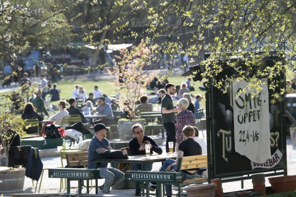 People gather for a drink at an outdoor bar in Stockholm, Sweden, Wednesday April 22, 2020 despite the coronavirus COVID-19 outbreak. (Anders Wiklund/TT via AP)