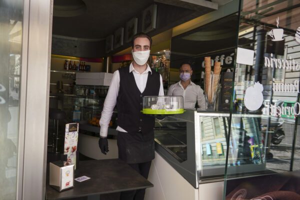 Bartender Antonio delivers coffee in Naples, Monday, April 27, 2020. Region Campania allowed cafes and pizzerias to reopen for delivery Monday, as Italy it is starting to ease its lockdown after a long precautionary closure due to the coronavirus outbreak. (AP Photo/Andrew Medichini)