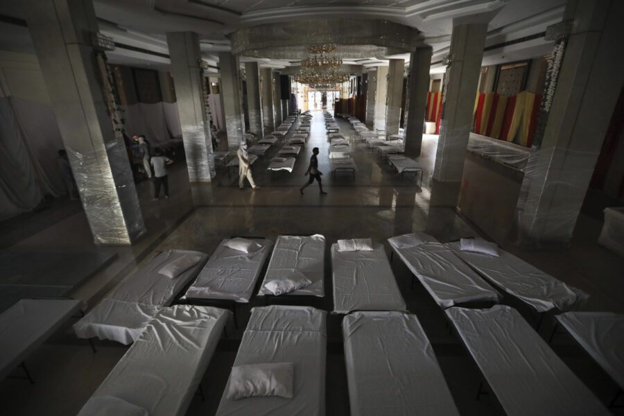 Workers walk across a banquet hall which is generally used for weddings that has been converted to makeshift coronavirus hospital as the Indian capital struggles to contain a spike in cases. in New Delhi, India, Monday, June 15, 2020. India is the fourth hardest-hit country by the COVID-19 pandemic in the world after the U.S., Russia and Brazil. (AP Photo/Manish Swarup)