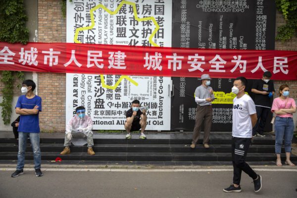 People wait outside a COVID-19 testing site after they were ordered by the government to be tested after potentially being exposed to the coronavirus outbreak at a wholesale food market in Beijing, Wednesday, June 17, 2020. As the number of cases of COVID-19 in Beijing climbed in recent days following an outbreak linked to a wholesale food market, officials announced they had identified hundreds of thousands of people who needed to be tested for the coronavirus. (AP Photo/Mark Schiefelbein)