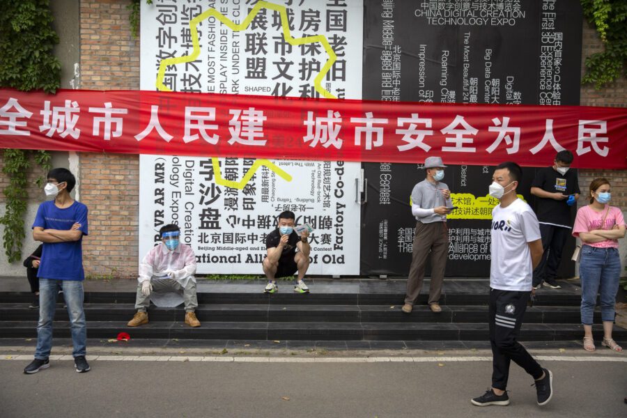 People wait outside a COVID-19 testing site after they were ordered by the government to be tested after potentially being exposed to the coronavirus outbreak at a wholesale food market in Beijing, Wednesday, June 17, 2020. As the number of cases of COVID-19 in Beijing climbed in recent days following an outbreak linked to a wholesale food market, officials announced they had identified hundreds of thousands of people who needed to be tested for the coronavirus. (AP Photo/Mark Schiefelbein)