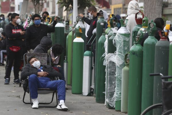 FILE – In this Monday, June 8, 2020 file photo, people wearing masks amid the COVID-19 coronavirus pandemic wait for hours, some for 10 hours, to refill their oxygen tanks at a shop in Callao, Peru. Long neglected hospitals around the world are reporting shortages of oxygen as they confront the spread of the disease. (AP Photo/Martin Mejia)