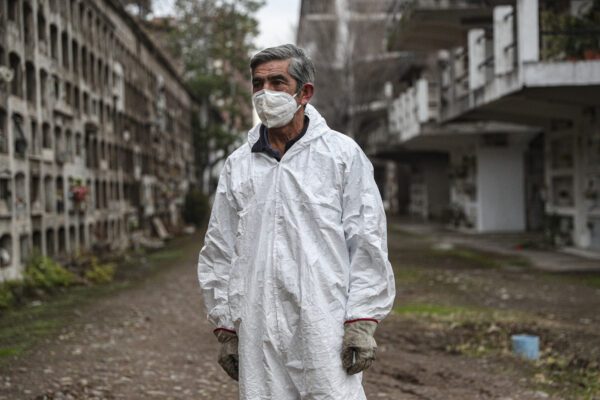 Cemetery worker Mauricio Pardo finishes a day of work at the "Cementerio Catolico" in Santiago, Chile, Saturday, June 27, 2020. The Ministry of Health reported on Saturday the highest number of deaths in Chile since the start of the new coronavirus pandemic. (AP Photo/Esteban Felix)