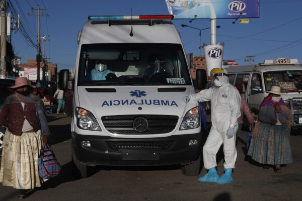 A health worker in full protective gear stands next to an ambulance waiting to drop off a COVID-19 patient at the Del Norte Hospital, which is treating COVID-19 patients exclusively, in El Alto, Bolivia, Wednesday, July 8, 2020. According to doctors at the facility, the hospital is at full capacity, including its ICU unit. (AP Photo/Juan Karita)
