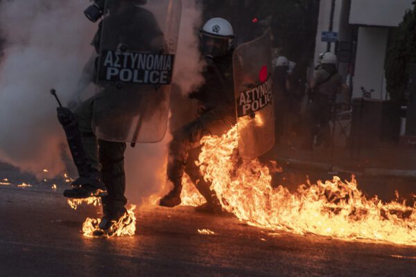 Riot police officers try to avoid patrol bombs thrown by protesters outside the Greek Parliament during a demonstration against new protest law in Athens, on Thursday, July 9, 2020. Violence has broken out in Athens during a mass demonstration against plans to curb public protests. (AP Photo/Petros Giannakouris)