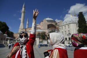 People, dropped in Turkish flags, chant slogans, outside the Byzantine-era Hagia Sophia, one of Istanbul’s main tourist attractions in the historic Sultanahmet district of Istanbul, following Turkey’s Council of State’s decision, Friday, July 10, 2020.Turkey’s Council of State, threw its weight behind a petition brought by a religious group and annulled a 1934 cabinet decision that changed the 6th century building into a museum. The ruling allows the government to restore the Hagia Sophia’s previous status as a mosque.The decision was in line with the Turkish President’s Recep Tayyip Erdogan’s calls to turn the hugely symbolic world heritage site into a mosque despite widespread international criticism, including from the United States and Orthodox Christian leaders. (AP Photo/Emrah Gurel)