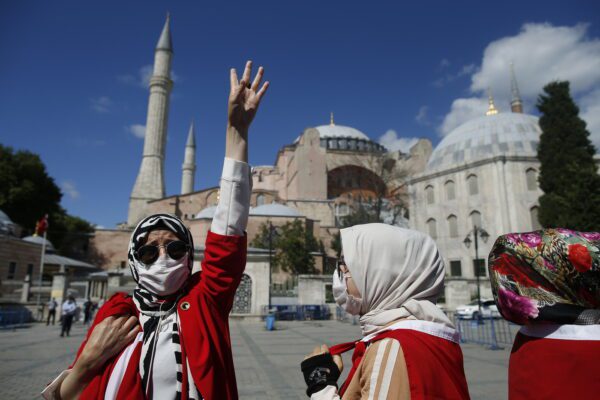 People, dropped in Turkish flags, chant slogans, outside the Byzantine-era Hagia Sophia, one of Istanbul’s main tourist attractions in the historic Sultanahmet district of Istanbul, following Turkey’s Council of State’s decision, Friday, July 10, 2020.Turkey’s Council of State, threw its weight behind a petition brought by a religious group and annulled a 1934 cabinet decision that changed the 6th century building into a museum. The ruling allows the government to restore the Hagia Sophia’s previous status as a mosque.The decision was in line with the Turkish President’s Recep Tayyip Erdogan’s calls to turn the hugely symbolic world heritage site into a mosque despite widespread international criticism, including from the United States and Orthodox Christian leaders. (AP Photo/Emrah Gurel)