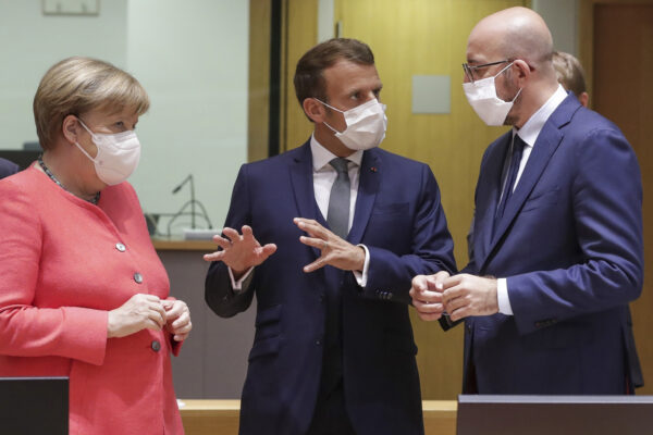 European Council President Charles Michel, right, speaks with French President Emmanuel Macron, center, and German Chancellor Angela Merkel during a round table meeting at an EU summit in Brussels, Friday, July 17, 2020. Leaders from 27 European Union nations meet face-to-face on Friday for the first time since February, despite the dangers of the coronavirus pandemic, to assess an overall budget and recovery package spread over seven years estimated at some 1.75 trillion to 1.85 trillion euros. (Stephanie Lecocq, Pool Photo via AP)