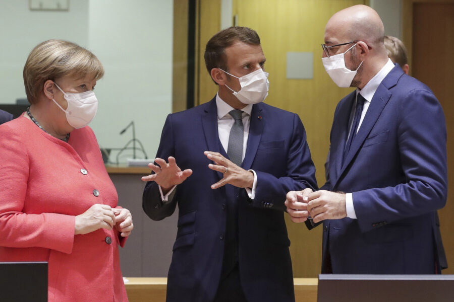 European Council President Charles Michel, right, speaks with French President Emmanuel Macron, center, and German Chancellor Angela Merkel during a round table meeting at an EU summit in Brussels, Friday, July 17, 2020. Leaders from 27 European Union nations meet face-to-face on Friday for the first time since February, despite the dangers of the coronavirus pandemic, to assess an overall budget and recovery package spread over seven years estimated at some 1.75 trillion to 1.85 trillion euros. (Stephanie Lecocq, Pool Photo via AP)