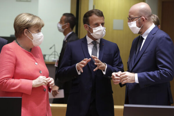 European Council President Charles Michel, right, speaks with French President Emmanuel Macron, center, and German Chancellor Angela Merkel during a round table meeting at an EU summit in Brussels, Friday, July 17, 2020. Leaders from 27 European Union nations meet face-to-face on Friday for the first time since February, despite the dangers of the coronavirus pandemic, to assess an overall budget and recovery package spread over seven years estimated at some 1.75 trillion to 1.85 trillion euros. (Stephanie Lecocq, Pool Photo via AP)