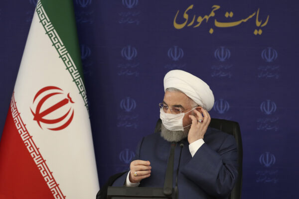 In this photo released by the official website of the office of the Iranian Presidency, President Hassan Rouhani adjusts his face mask in a meeting of the national headquarters of the fight against the COVID-19, in Tehran, Iran, Saturday, July 18, 2020. He estimated as many as 25 million Iranians could have been infected with the coronavirus since the outbreak’s beginning, citing an Iranian Health Ministry study that has so far not been made public, the state-run IRNA news agency reported. Writing in Farsi at top right reads, "The Presidency." (Iranian Presidency Office via AP)