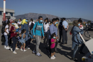 A group of migrant children with health issues board a plane to Germany, at Athens International Airport, Friday, July 24, 2020. German Foreign Heiko Maas, on a visit to Athens this week, said his country would follow through in its pledge to assist Greece with the relocation of unaccompanied minors and other children at refugee camps in Greece. (AP Photo/Petros Giannakouris)