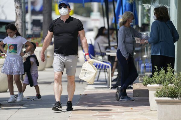 People wear masks while walking on Sunset Blvd, Thursday, July 2, 2020, in West Hollywood, Calif. Sheriff’s deputies in West Hollywood will issue citations to people who are not wearing masks in public, ramping up enforcement that previously had largely been imposed without penalties. (AP Photo/Ashley Landis)