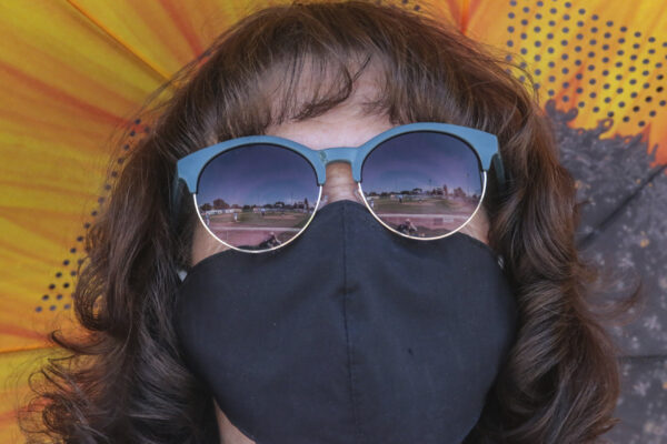 A woman wears a mask as she watches a AA American Legion game at Melaleuca Field in Idaho Falls, Idaho on Friday, July 31, 2020. (John Roark/The Idaho Post-Register via AP)