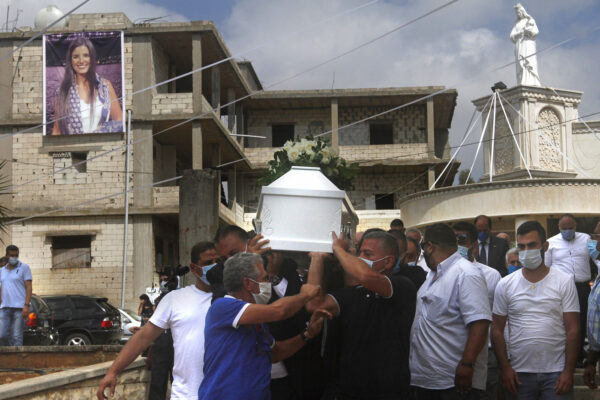 Relatives of Nicole al-Helou, who was killed by the explosion Tuesday that hit the seaport of Beirut, carry her coffin during her funeral, in Sarba village, southern Lebanon, Thursday, Aug. 6, 2020. French President Emmanuel Macron said an independent, transparent investigation into the massive explosion in Beirut is "owed to the victims and their families" by Lebanese authorities. During Macron’s visit to the city on Thursday, angry crowds approached him and the Beirut governor as they walked through a blast-torn street. (AP Photo/Mohammed Zaatari)