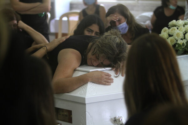 The mother of Nicole al-Helou, who was killed by the explosion Tuesday that hit the seaport of Beirut, mourns on her daughter’s coffin during her funeral, in Sarba village, southern Lebanon, Thursday, Aug. 6, 2020. French President Emmanuel Macron said an independent, transparent investigation into the massive explosion in Beirut is "owed to the victims and their families" by Lebanese authorities. During Macron’s visit to the city on Thursday, angry crowds approached him and the Beirut governor as they walked through a blast-torn street. (AP Photo/Mohammed Zaatari)