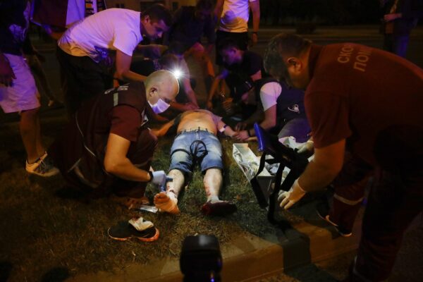 Paramedics treat a wounded person after clashes with police man in Minsk, Belarus, Sunday, Aug. 9, 2020. Police and protesters clashed in Belarus’ capital and the major city of Brest on Sunday after the presidential election in which the authoritarian leader who has ruled for a quarter-century sought a sixth term in office. (AP Photo/Sergei Grits)