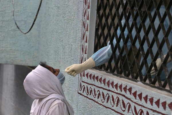 A woman gets her nasal swab sample taken for COVID-19 test at a government health center in Hyderabad, India, Sunday, Aug. 16, 2020. India is the third hardest-hit country by the pandemic in the world after the United States and Brazil. (AP Photo/Mahesh Kumar A.)