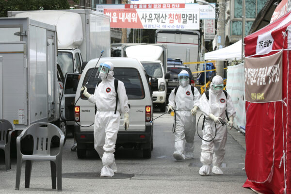 In this on Sunday, Aug. 16, 2020 photo, public officials disinfect as a precaution against the coronavirus near the Sarang Jeil Church in Seoul, South Korea. South Korean health officials said Monday, Aug. 17, they so far found more than 300 coronavirus infections tied to a northern Seoul church led by one of President Moon Jae-in’s biggest critics, which emerged as a major cluster amid growing fears about a massive outbreak in the greater capital region. (Park Dong-joo/Yonhap via AP)