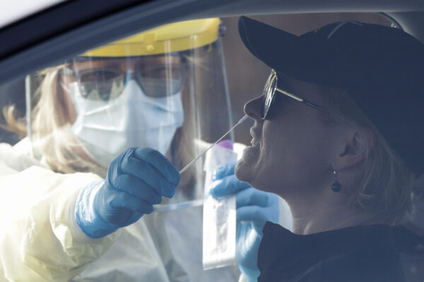 Medical staff take a COVID-19 test from a visitor to a drive through community based assessment centre in Christchurch, New Zealand, Thursday, Aug. 13, 2020. Health authorities in New Zealand are scrambling to trace the source of a new outbreak of the coronavirus as the nation’s largest city, Auckland, goes back into lockdown (AP Photo/Mark Baker)