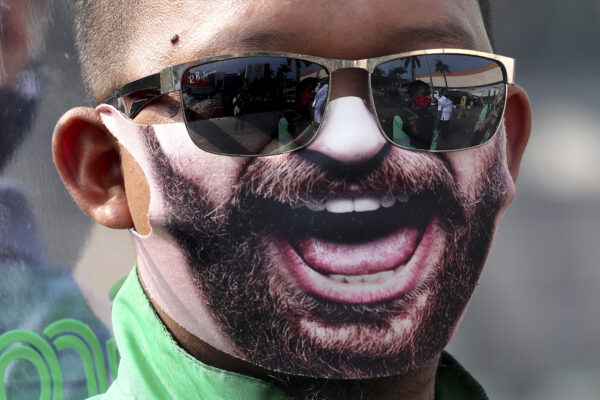 A man wears a decorated face mask as he waits to be tested for the coronavirus in Tangerang, Indonesia on July 21, 2020. (AP Photo/Tatan Syuflana)