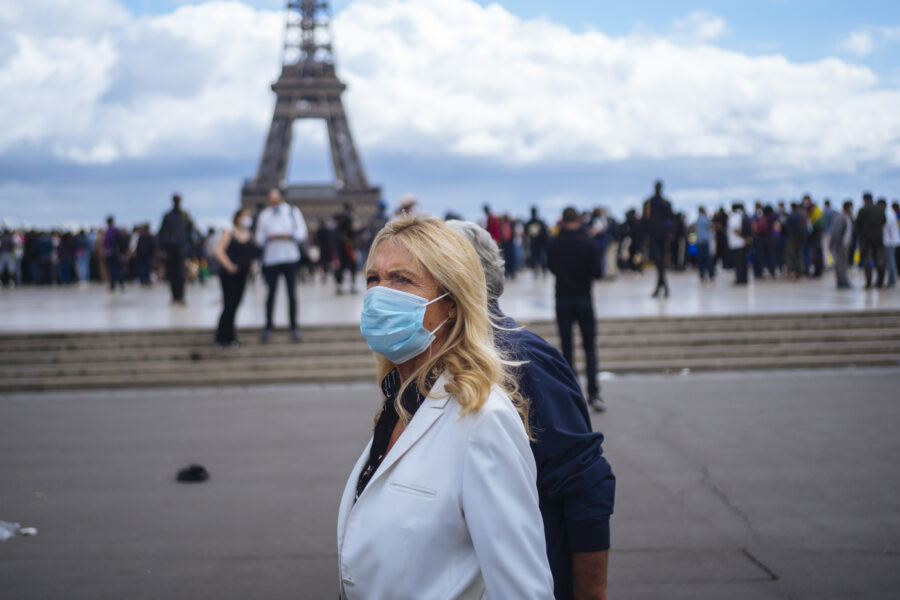 People wearing face masks stroll at Trocadero plaza near the Eiffel Tower, in Paris, Saturday, Aug. 29, 2020. France registered more than 7,000 new virus infections in a single day Friday, up from several hundred a day in May and June, in part thanks to ramped-up testing. Masks are now required everywhere in public in Paris as authorities warn that infections are growing exponentially. (AP Photo/Kamil Zihnioglu)
