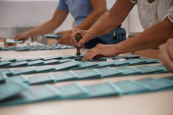 Volunteers stamp ballots at a polling station, in Rome, Saturday, Sept. 19, 2020. Italians will vote in a national referendum next Sept. 20 and 21 to say if they want to reduce from 630 to 400, in the Chamber of Deputies, and from 315 to 200, in the Senate, the number of representatives. (AP Photo/Andrew Medichini)