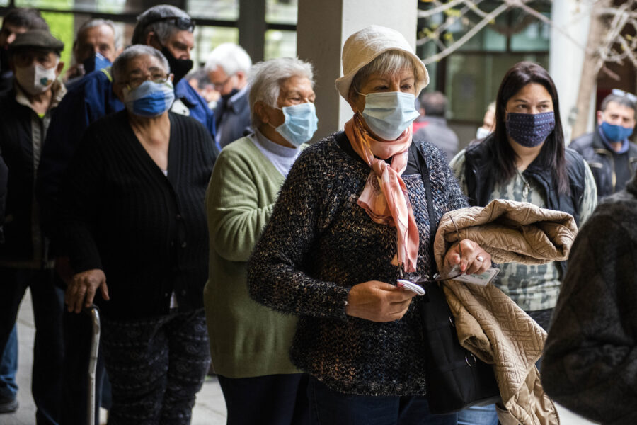 People wearing face masks to avoid the spread of the new coronavirus line up at a polling station during the municipal election in Montevideo, Uruguay, Sunday, Sept. 27, 2020. (AP Photo/Matilde Campodonico)