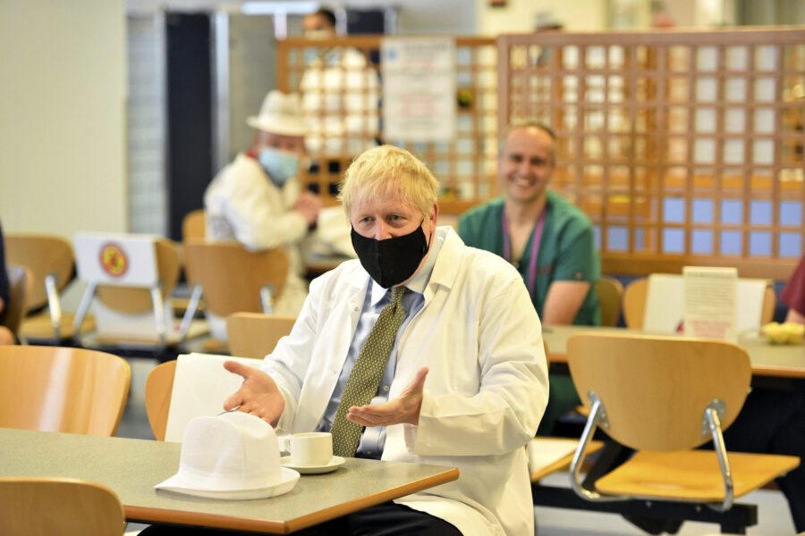 Britain’s Prime Minister Boris Johnson speaks to members of staff in the canteen during a visit to Royal Berkshire Hospital, Reading, England, Monday Oct. 26, 2020, to mark the publication of a new review into hospital food. (Jeremy Selwyn/Pool via AP)