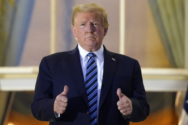 President Donald Trump stands on the balcony outside of the Blue Room as returns to the White House Monday, Oct. 5, 2020, in Washington, after leaving Walter Reed National Military Medical Center, in Bethesda, Md. Trump announced he tested positive for COVID-19 on Oct. 2. (AP Photo/Alex Brandon)